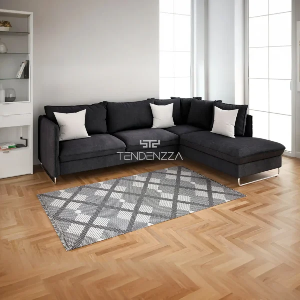 Alfombra Lora SD88G grey, un tapete para la sala principal moderna. Piso en madera, sofá en ele color negro con una alfombra en forma rectangular de 2.30 mts de largo por 1.60 mts de ancho, base en tono gris claro con patrón de rombos gris oscuro y blanco. Alfombra tejida importada de Turquía. Alfombras y tapetes en Bucaramanga